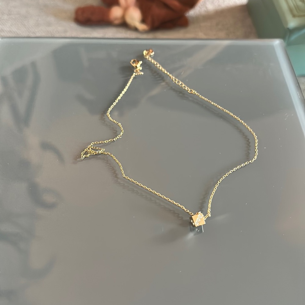 Gold die 3D necklace with diamonds. 2 are missing.